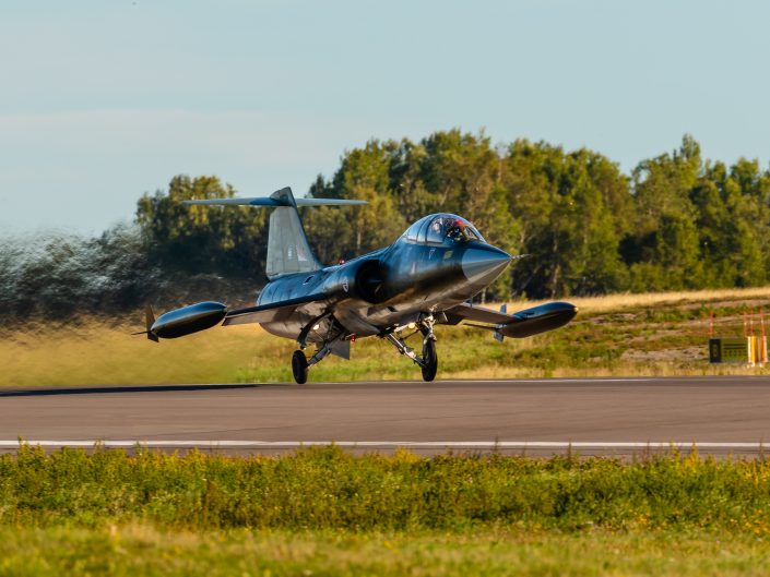 Jet landing on runway with smoke