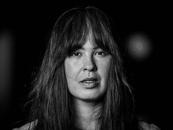 Dark background with long hair silhouette.